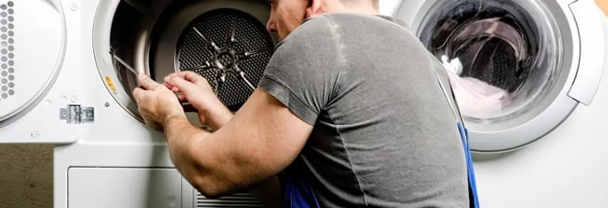 Dryer repair technician fixing a clothes dryer drum in Miami, FL