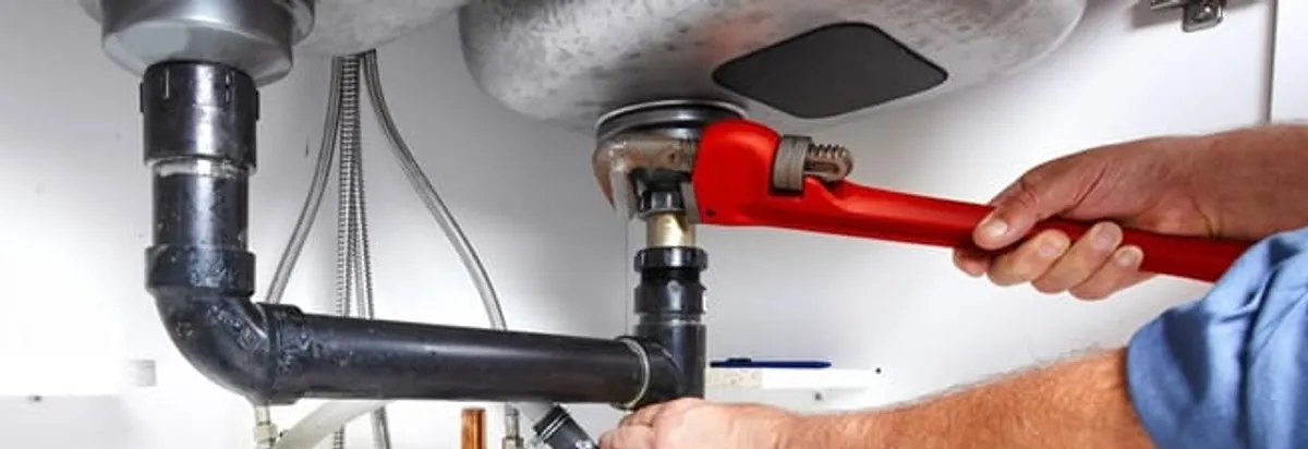 Garbage disposal repair technician tightening the sink drain and disposal connection in Miami, FL