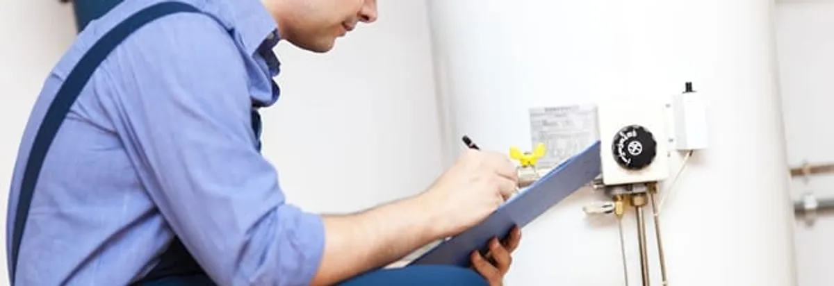 Water heater repair technician inspecting the unit and recording service notes in Miami, FL